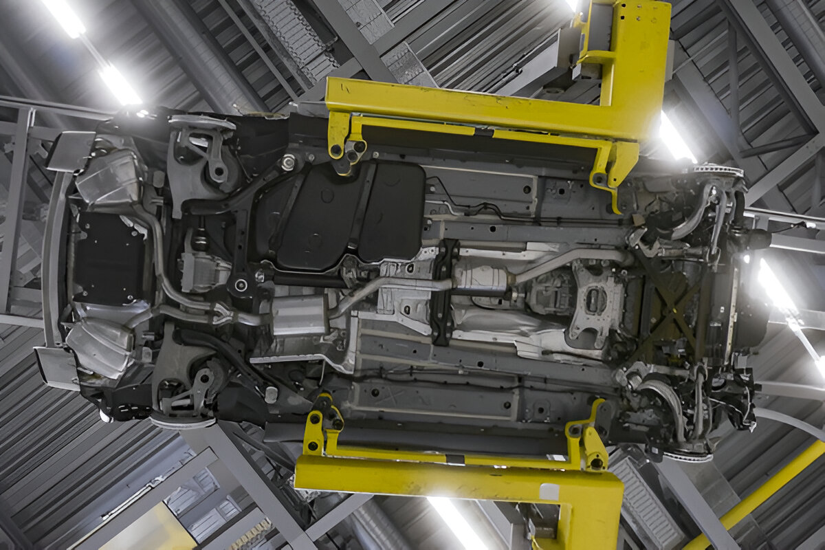 Carro visto de baixo em linha de montagem em posição de inspeção da parte inferior